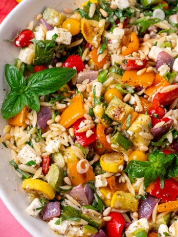 Close-up of lemon orzo salad with roasted zucchini, bell peppers, red onion, feta, basil and pine nuts