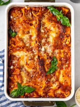 Baked zucchini lasagna topped with melted mozzarella, Parmesan and fresh basil