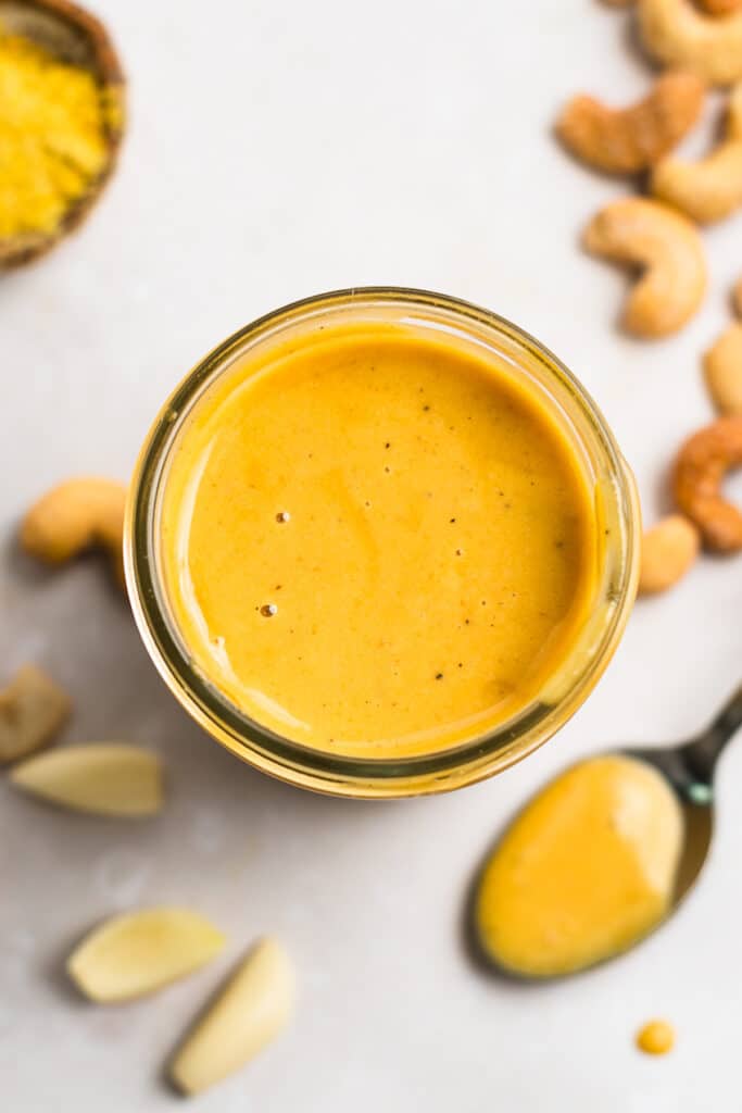 Mason jar with vibrant yellow cashew dressing in it