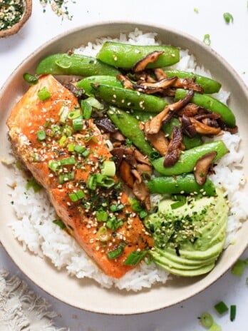 Plate with rice, avocado, sauteed shiitake mushrooms and snap peas and salmon with miso butter sauce