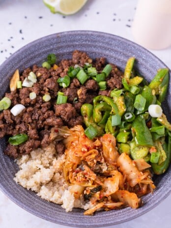 Bowl with garlic ginger ground beef, quinoa, kimchi and a smashed cucumber salad