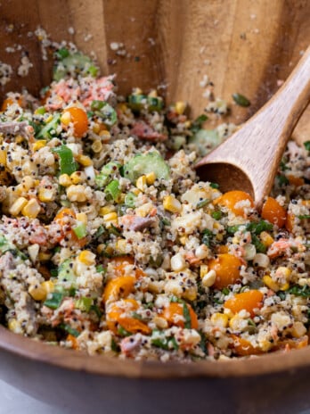 Large wooden bowls with salmon quinoa salad tossed with jalapeno lime dressing
