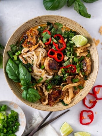 bowl of thai-inspired chicken meatball soup with fresh herbs and jalapeno peppers