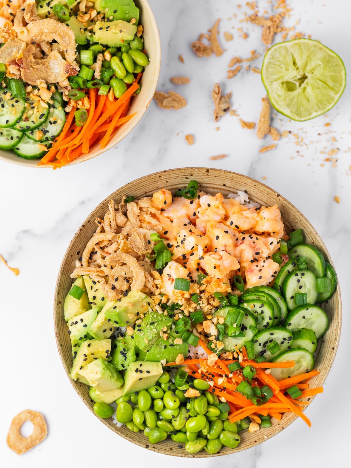 shrimp poke bowl with creamy sweet chili shrimp, crispy onions, avocado, edamame, cucumbers and carrots