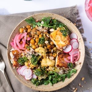 bowl with quinoa, cauliflower, chickpeas, pickled red onion, arugula, radish and fried feta
