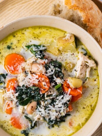 bowl of creamy chicken soup with kale, potatoes, carrots and parmesan cheese