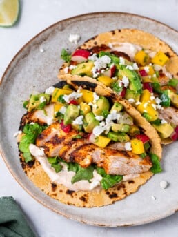 plate with two chicken tacos and mango avocado salsa