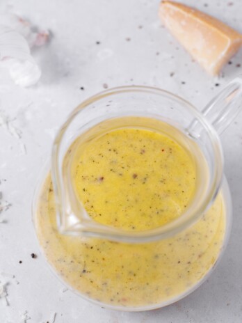 small glass pitcher of parmesan vinaigrette