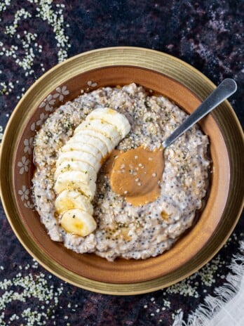 bowl of oatmeal with a spoonful of peanut butter and banana slices