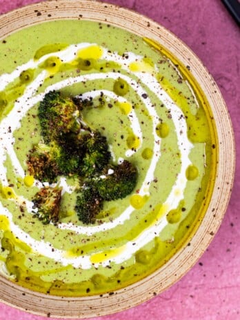 bowl with broccoli feta soup topped with roasted broccoli and swirled with olive oil and heavy cream