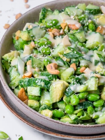 large bowl with cucumber, edamame, cashews, green onions and creamy miso dressing