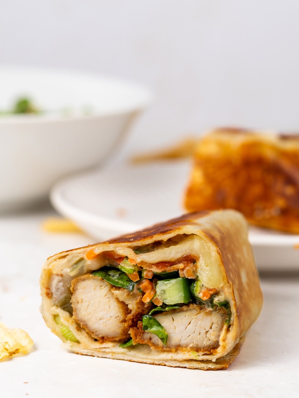 inside of honey mustard chicken wrap- melty cheese, bacon and crispy chicken strip