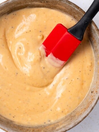 red spatula stirring creamy spicy honey mustard sauce