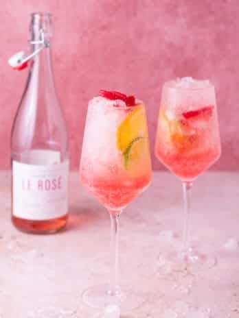 two wine glasses with rosé spritzer, bottle of rosé wine