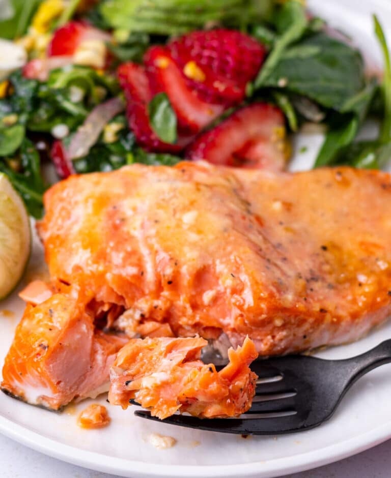 Sweet chili salmon filet flaked with a bite on a fork