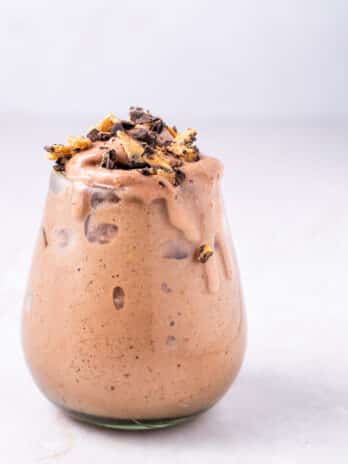 glass with peanut butter cup smoothie topped with peanut butter cups