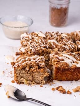 spoon with icing and sliced oatmeal apple cake