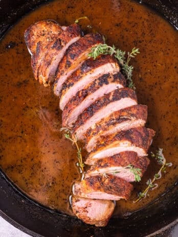 cast iron skillet with sliced pork tenderloin