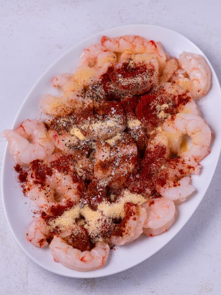 white plate with shrimp with seasonings