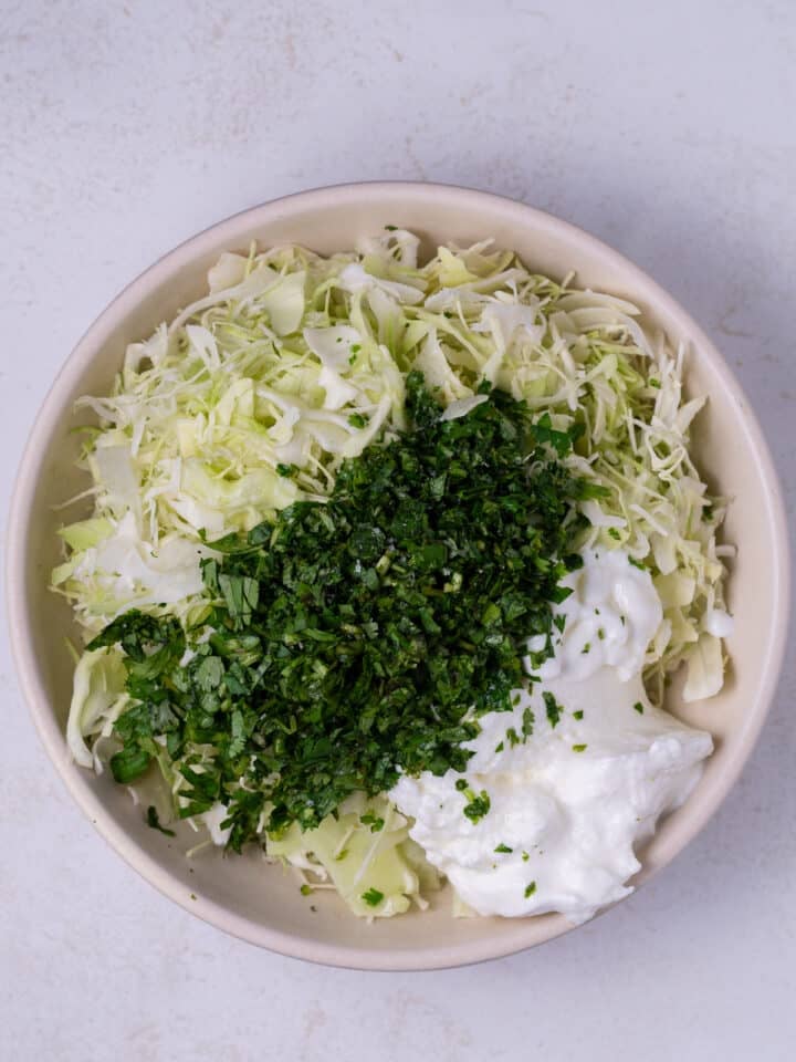 bowl with shredded cabbage, cilantro and Greek yogurt