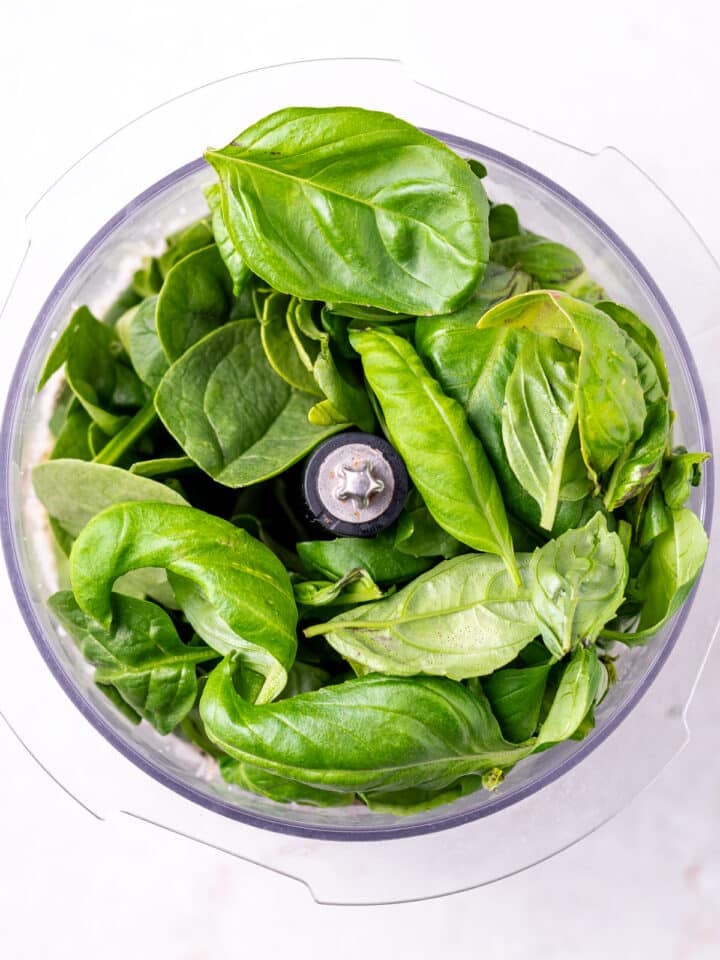 spinach and basil leaves in a food processor