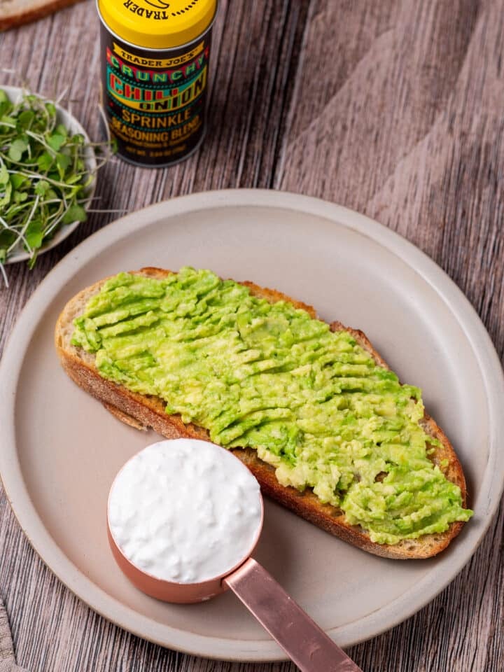 slice of sourdough with a measuring cup of cottage cheese
