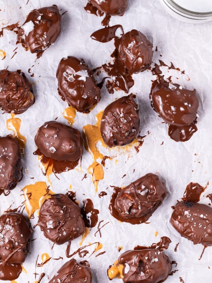 chocolate covered peanut butter snickers dates on a piece of parchment paper