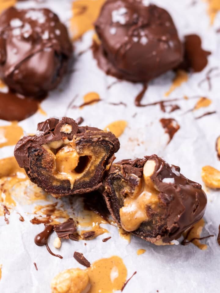 snickers date- chocolate covered date filled with peanut butter and peanuts and topped with flaky sea salt, sliced in half