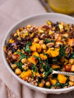 fork in farro grain bowl with squash, kale, chickpeas and shallots