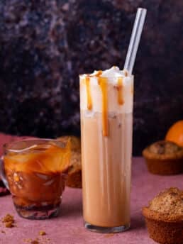 tall glass with iced salted caramel latte, small pitcher of salted caramel sauce, pumpkin muffins
