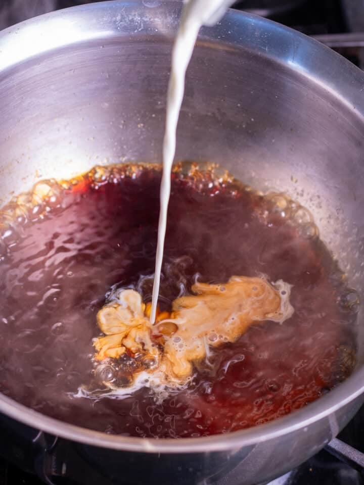 pouring heavy cream into the burnt sugar mixture