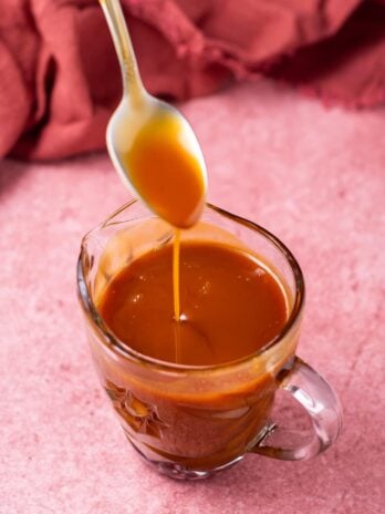 spoon dripping into a small pitcher of salted caramel syrup