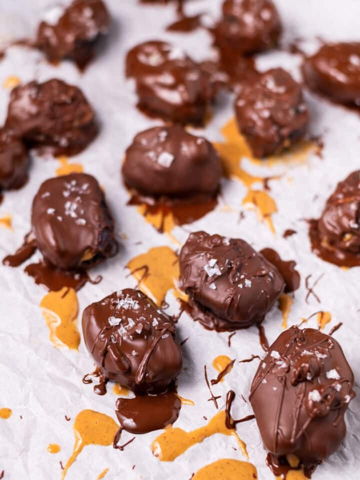 chocolate covered peanut butter snickers dates on a piece of parchment paper