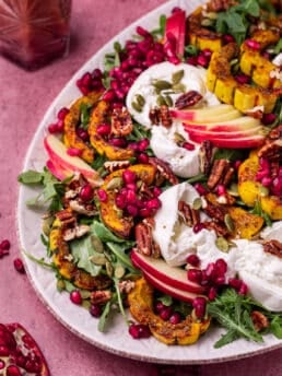 arugula salad with burrata cheese, delicata squash, pomegranate arils, apples, pecans and pumpkin seeds