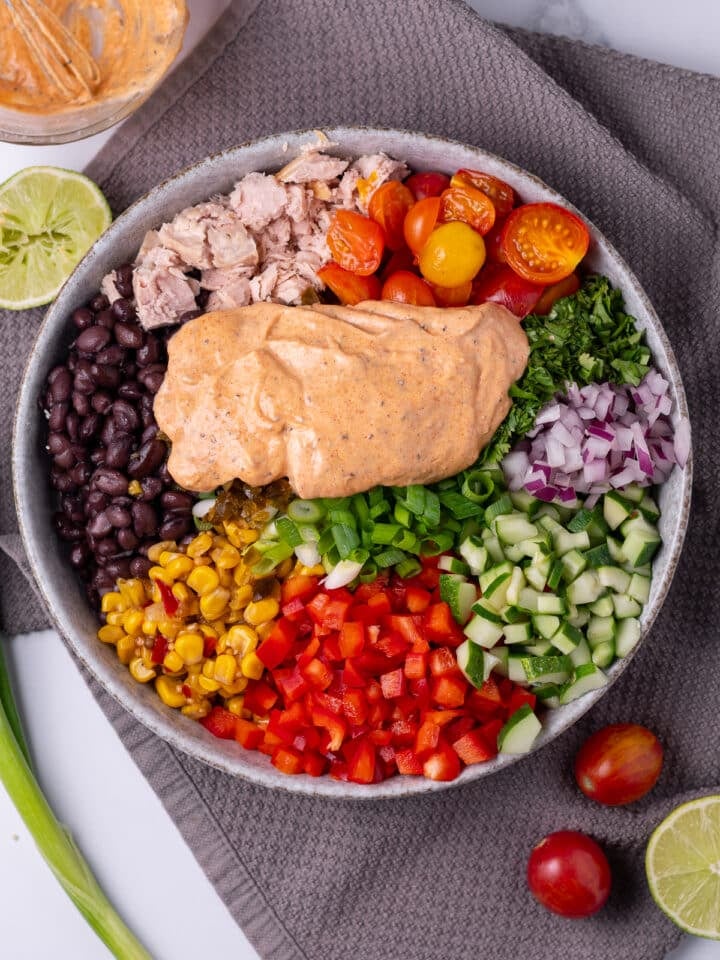 creamy dressing added to the salad bowl 
