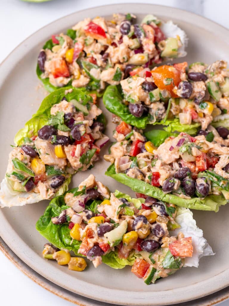 Mexican tuna salad with black beans, corn salsa, pickled jalapeños, and veggies scooped into lettuce leaves