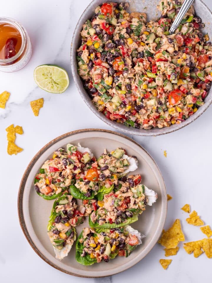 large serving bowl of Mexican-inspired tuna salad and serving plate with five lettuce cups filled with salad