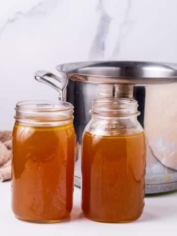 two quarts of homemade turkey stock and a large stockpot in the background