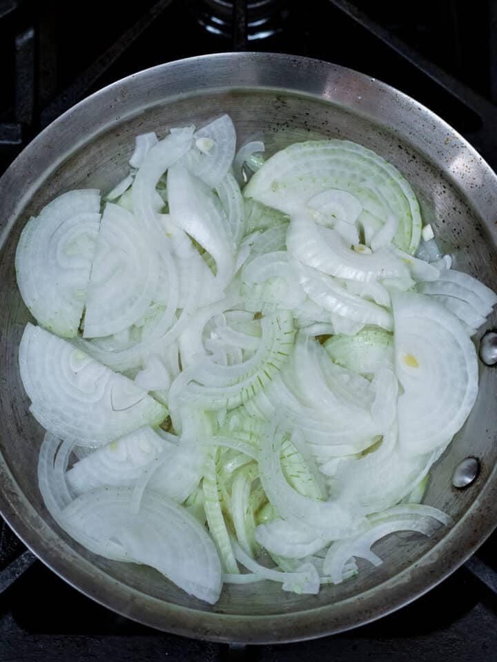 sliced onions in stainless steel skillet