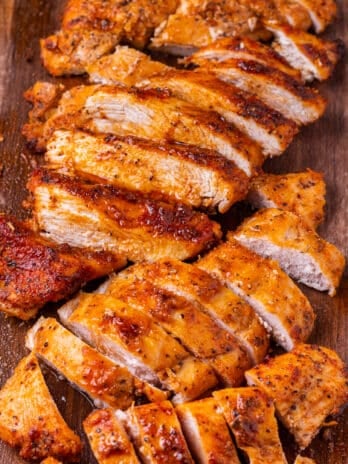 thinly sliced seasoned chicken breast on a cutting board