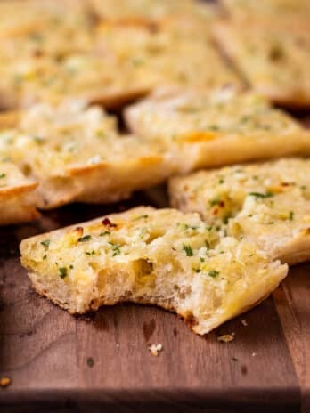 piece of ciabatta garlic bread with a bite taken out of it.