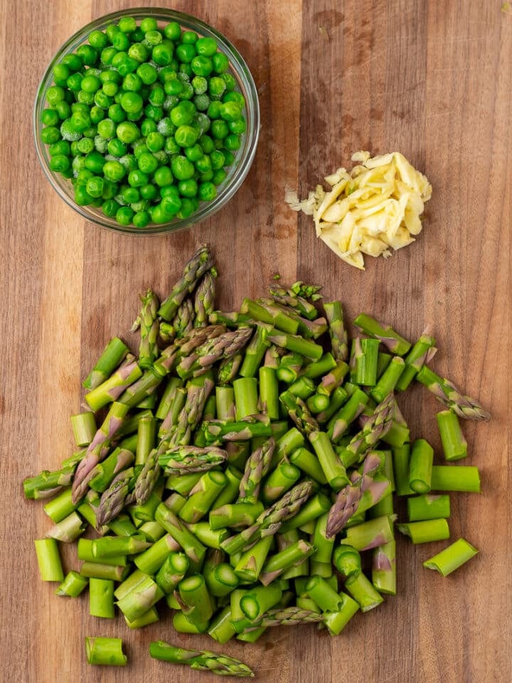chopped asparagus and garlic, peas in a small bowl