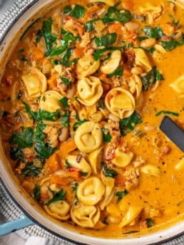 close up view of creamy tortellini soup with sun-dried tomatoes and sausage
