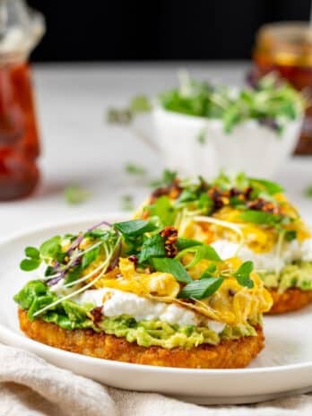 hashbrown patty with avocado, cottage cheese, scrambled eggs and microgreens