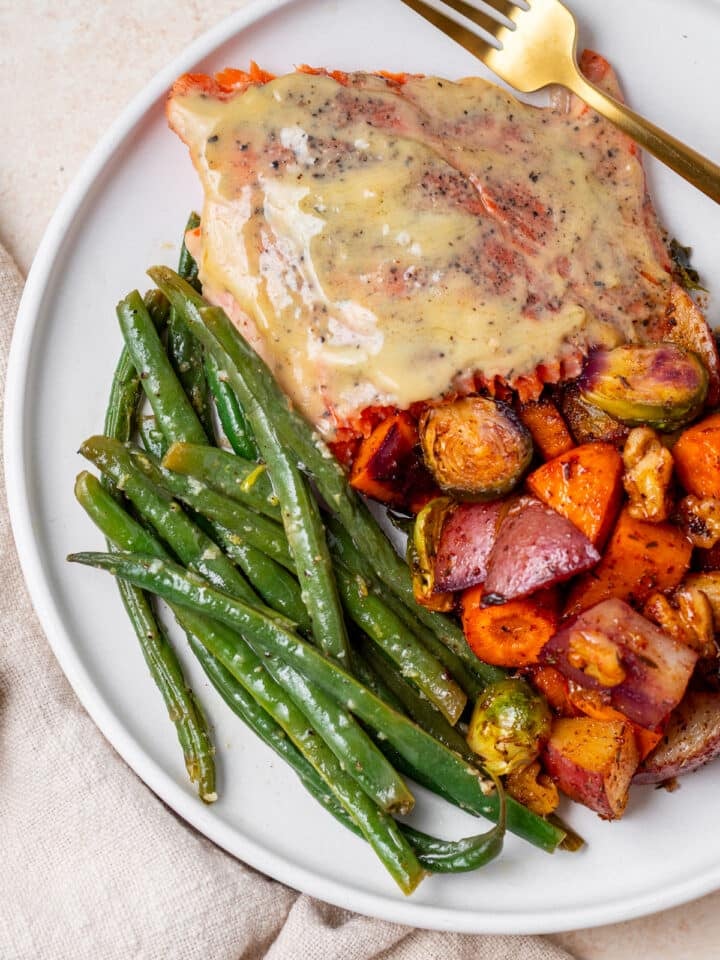 lemon butter green beans, roasted vegetables and maple mustard salmon on a plate