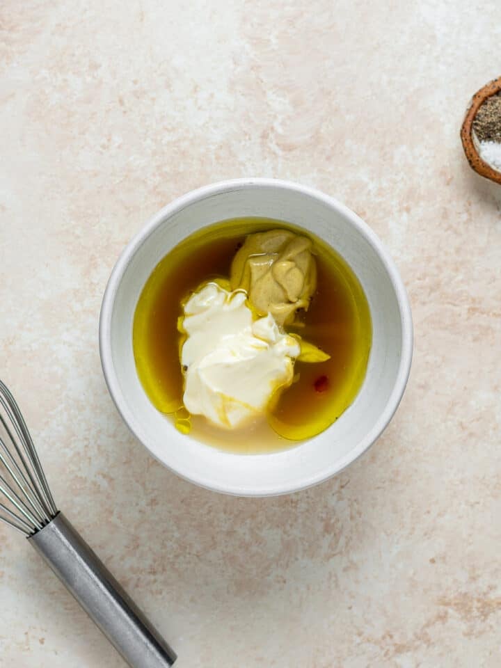 small bowl with olive oil, mayo, mustard, lemon juice and syrup