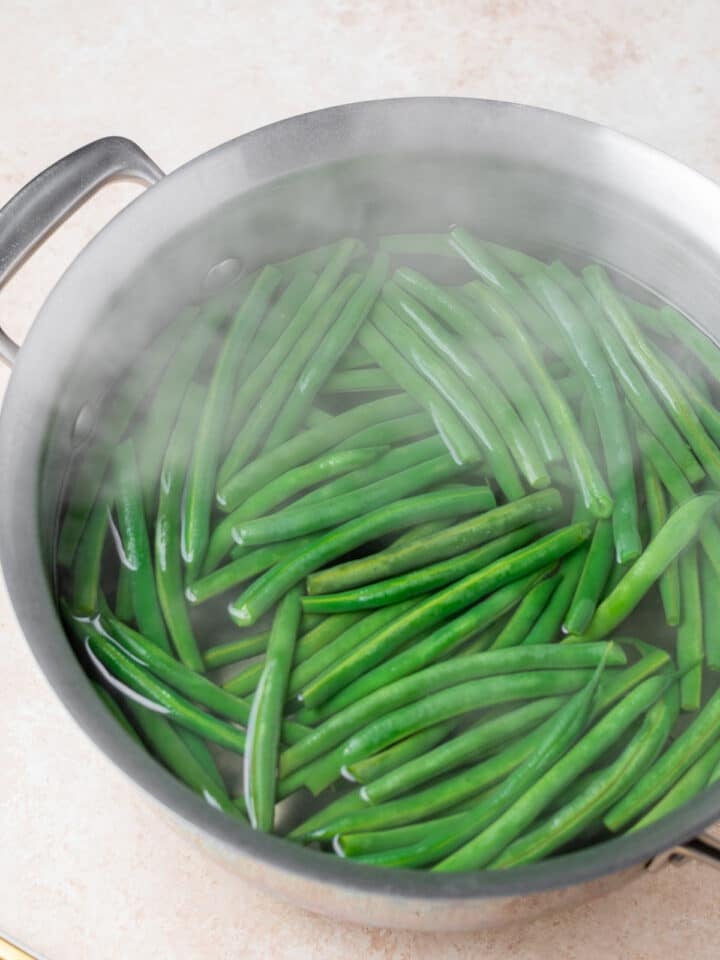 stainless steel pot with boiling water and green beans