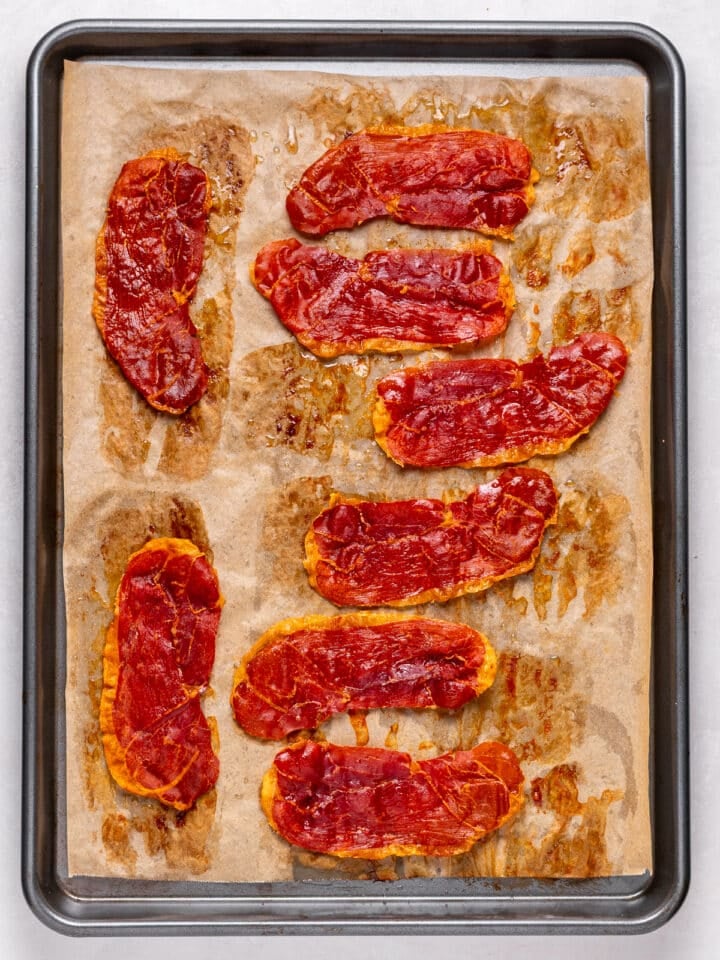 baked and crispy prosciutto slices lined up on a sheet pan