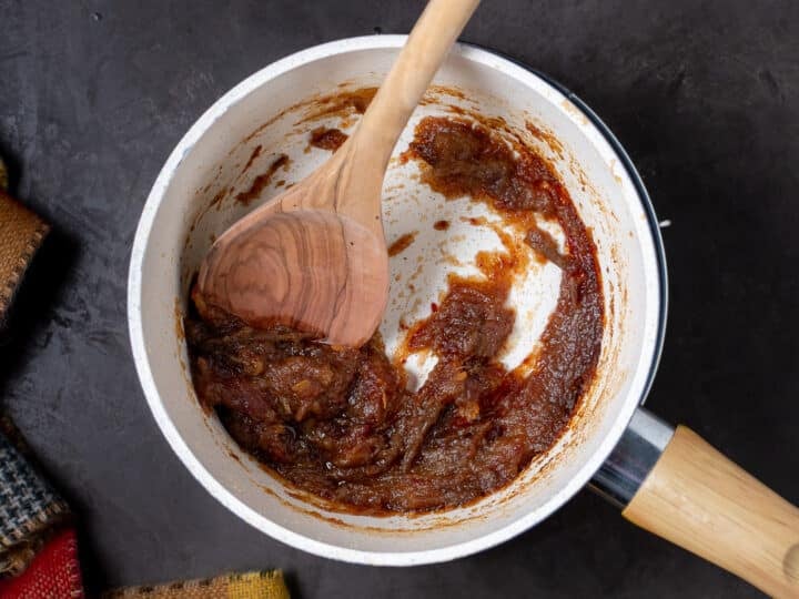 wooden spoon smashing dates into a thick paste