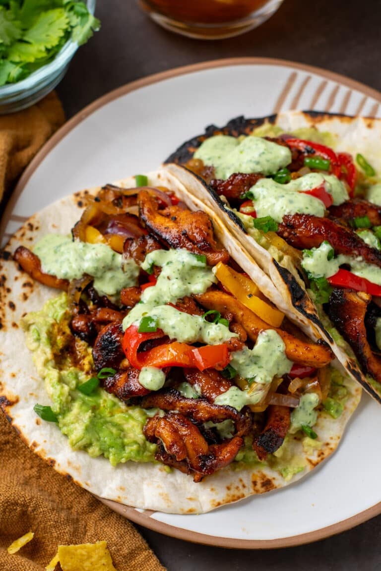 two tortillas filled with chipotle chicken, sauteed fajita veggies, guacamole and cilantro lime yogurt sauce